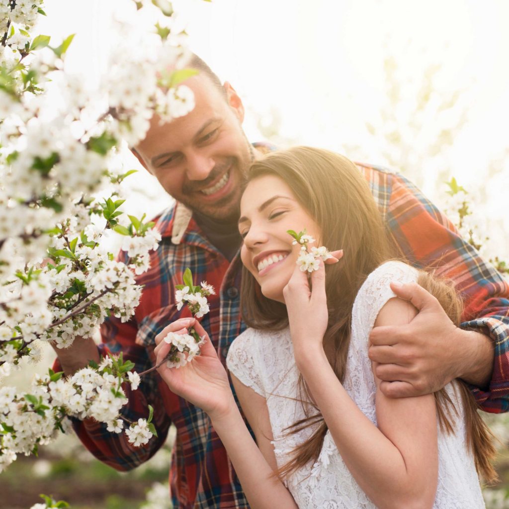 Couple in front of Spring flowers.